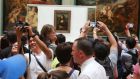  Visitors to the Louvre take photos of the Mona Lisa. Photograph: Owen Franken/New York Times