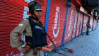 Security personnel stand guard in front of closed shops in Srinagar, as a tense lockdown in the region of seven million residents continued. Photograph: Tauseef Mustafa/AFP