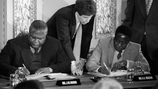 Joshua Nkomo and Robert Mugabe signing the Rhodesia ceasefire agreement in London in December 1979. Photograph: PA