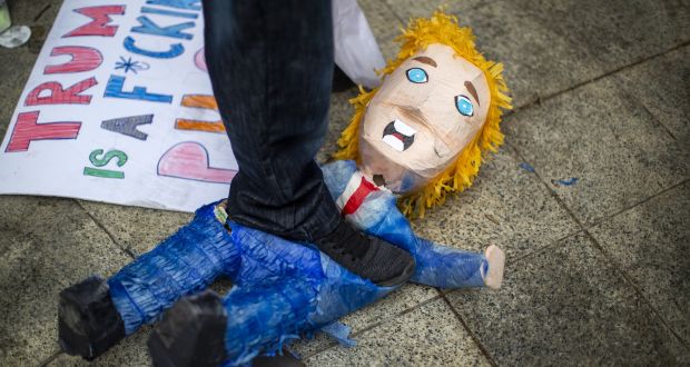  A counter-demonstrator steps on a pinata during a President Donald Trump rally in Los Angeles, California. Photograph:  David McNew/Getty