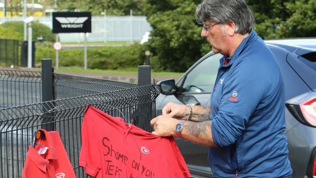 A former Wrightbus employee puts up a T-shirt with the words ‘Shame on you Jeff Wright’ outside the factory in Co Antrim. Photograph: Paul McErlane
