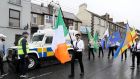 A colour party passes a police vehicle in Newry, Co Down on Sunday. The political party Saoradh had organised the parade to commemorate hunger strikes. Photograph: Brian Lawless/PA 