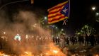A demonstrator waves a pro-independence Catalan Estelada flag tand The Black Flag of Catalonia during a protest  in Barcelona.  Photograph: Angel Garcia/Bloomberg