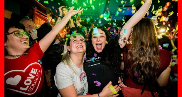 Martha Brown (left, grey t-shirt) with her partner Louise McCullough (right, black t-shirt) and equal marriage supporters at Maverick Bar in Belfast, celebrate the change to abortion and same sex marriage laws in Northern Ireland in the early hours of Tuesday morning. Photograph: Liam McBurney/PA Wire