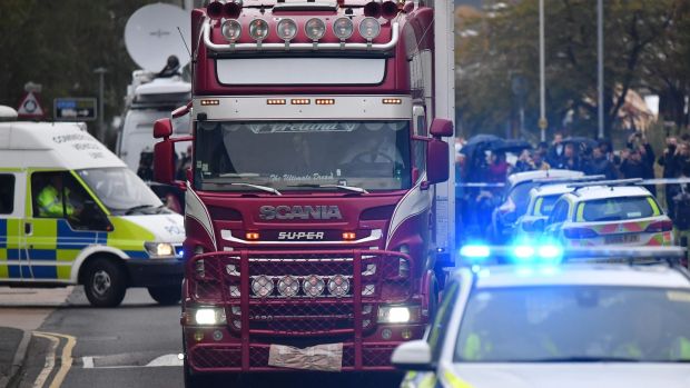 Police officers escort the lorry in which 39 dead bodies were discovered. Three more arrests have been made in the investigation. Photograph: Ben Stansall/AFP via Getty Images