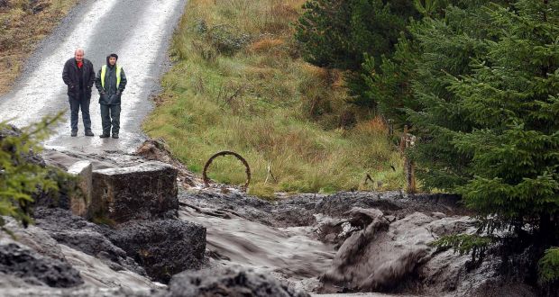 Two men watch as road is covered by a landslide in Derrybrien, Co Galway in 2003. Photograph: Joe Shaughnessy.