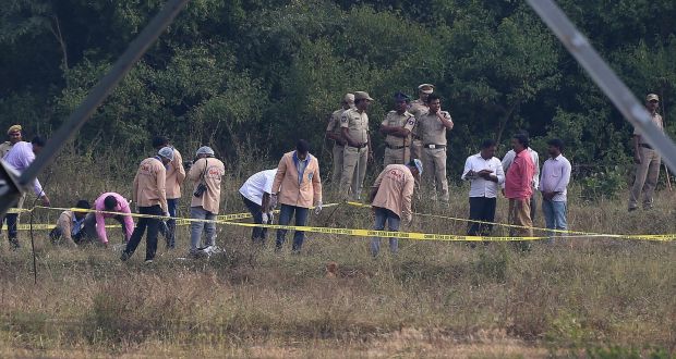 Policemen watch forensic experts at the site where four men suspected of raping and killing a woman were killed in Shadnagar, India, on Friday. Photograph: Mahesh Kumar/AP 
