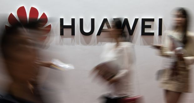  In this file photo taken on August 2, 2019 people walk past a Huawei logo during the Consumer Electronics Expo in Beijing.  (Photo by Fred DUFOUR / AFP) 