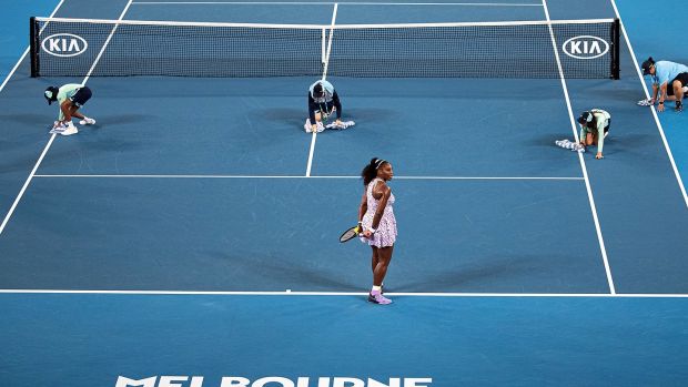 Serena Williams waits as ball kids dry the court during her women’s singles second round match against Tamara Zidansek. Photo: Roman Pilipey/EPA