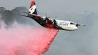  A C-130 Hercules plane from the New South Wales Rural Fire Service dropping fire retardent to protect a property during an operation to douse bushfires on January 10th. Photograph: Saeed Khan/AFP 