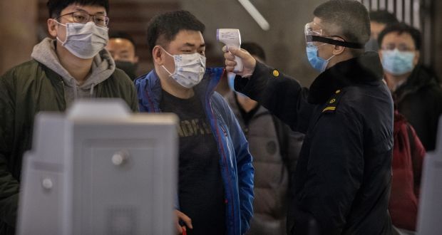  A  passenger who  arrived on the last bullet train from Wuhan to Beijing is checked for a fever by a health worker on Thursday. Photograph: Kevin Frayer/Getty Images