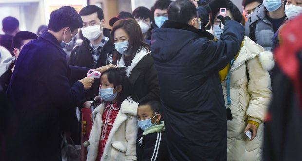 Officials  check the body temperature of passengers after a train from Wuhan arrives at Hangzhou railway station in China’s Zhejiang province.  Photograph:  STR/AFP via Getty Images