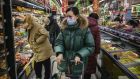 A  woman wears a protective mask and sunglasses in a supermarket  in Beijing. Photograph: Kevin Frayer/Getty Images