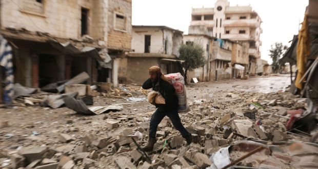 A man carries his belongings through a street destroyed in recent bombings by the Syrian government forces in the town of Sarmin, in Idblib province, Syria. Photograph: Ghaith Alsayed/AP