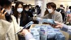 People wearing masks to prevent the coronavirus spreaing buy face masks at a department store on Friday in Seoul, South Korea. Photograph:  Chung Sung-Jun/Getty Images