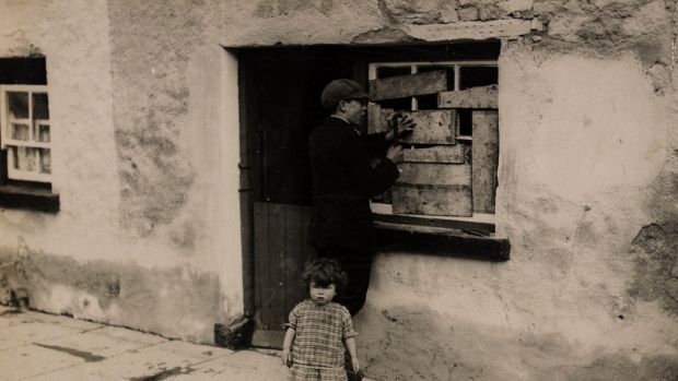 A boy boards up a broken window after a reprisal attack by crown forces in Templemore, Co Tipperary, in October 1920. Photograph courtesy of the National Library of Ireland