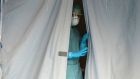 A medical staffer watches from a tent at the Brescia hospital, northern Italy. Photograph: AP Photo/Luca Bruno