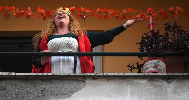 A woman sings from her balcony in Rome. Photograph: Reuters