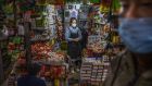 A Chinese shopkeeper waits for customers at a local market in Beijing on March 4th. A 55-year-old individual from Hubei province may have been the first person to have contracted Covid-19 in November last year. Photograph: Getty Images