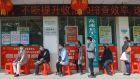 China presents itself as a lesson in how states can push back the deadly virus. Customers lining up to have their temperature taken before entering a bank in  China’s central Hubei province.  Photograph:   STR/AFP via Getty Images