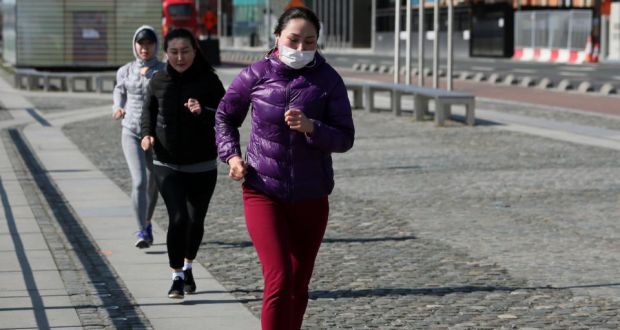 People follow social distancing guidelines as they go for a run in Dublin’s city centre. Photograph: Brian Lawless/PA Wire