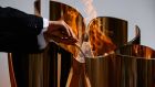 The Tokyo 2020 Olympic flame is transferred to the Olympic cauldron after it failed to light the first time as it goes on display at Ofunato, Iwate prefecture in Japan on Monday. Photograph: Philip Fong/AFP via Getty Images