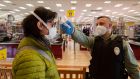 A customer has her temperature checked at the entrance of a supermarket in Milan, Italy, on Tuesday. Photograph: Marco Ottico/EPA
