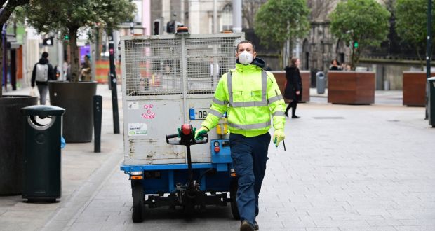 A Dublin City Council  worker wearing a mask. The ESRI  says  Covid-19 is  the greatest threat to the Irish economy  since the financial crisis.  Photograph: Aidan Crawley/EPA 