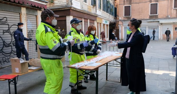 Municipal workers distribute masks and gloves at the Rialto market in Venice on Saturday, as new restrictions for open-air markets were implemented by the Veneto region to prevent the spread  of coronavirus. Photograph: Manuel Silvestri/Reuters