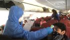 A Chilean health ministry official takes the temperature passengers on the flight out of Punta Arenas. Photograph: Peter Murtagh