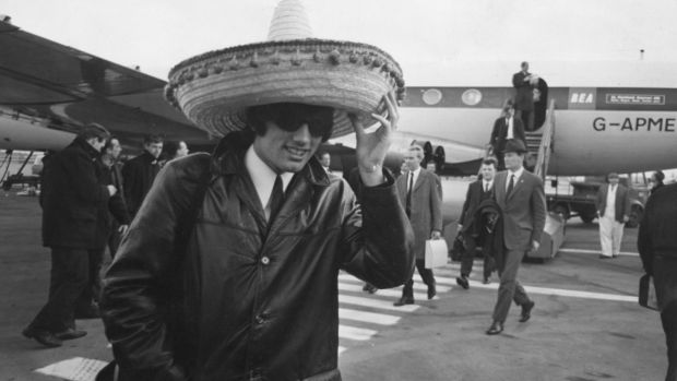 George Best arrives back from Manchester United’s win over Benfica in the European Cup quarter-final, second leg in March 1966. Best scored the first two goals in a 5-1 win at the Estádio da Luz. Photograph: Keystone/Hulton Archive/Getty Images)