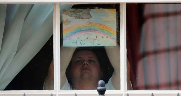 A member of staff signals a  symbol of hope from a window at 10 Downing Street. Photograph: Getty