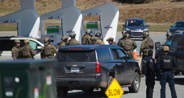 Royal Canadian Mounted Police officers at fuel station in Enfield, Nova Scotia, where a pursuit for a man believed responsible for shooting at least 16 people ended. Photograph: AP 
