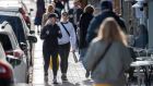 People pass by an outdoor restaurant in central Stockholm on Monday. Official guidance in Sweden says citizens can still go out for a meal as long as they stay ‘at arm’s length’ from each other. Photograph: Anders Wiklund/EPA