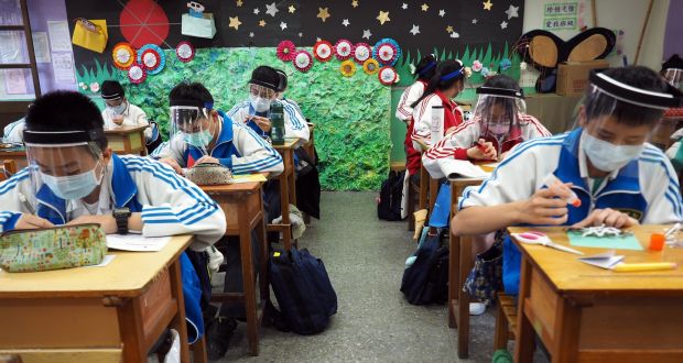 Students wear plastic face shields at the Nankan Junior High School in Taoyuan City, Taiwan: testing, contact tracing, travel bans, quarantines and masks in public places are Asian defence tools. Photograph: David Chang