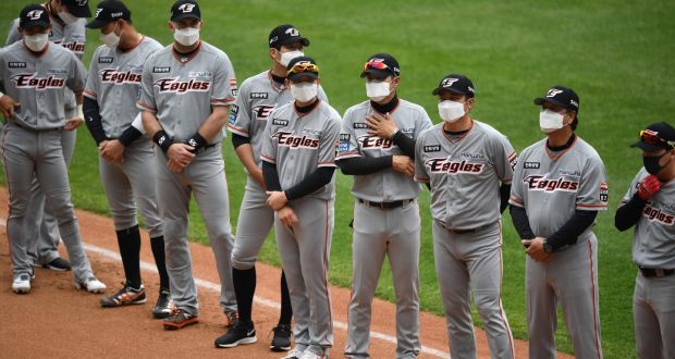 Hanwha Eagles players line up wearing face masks ahead of the opening game of South Korea’s new baseball season. Photograph: Jung Yeon-Je/Getty/AFP