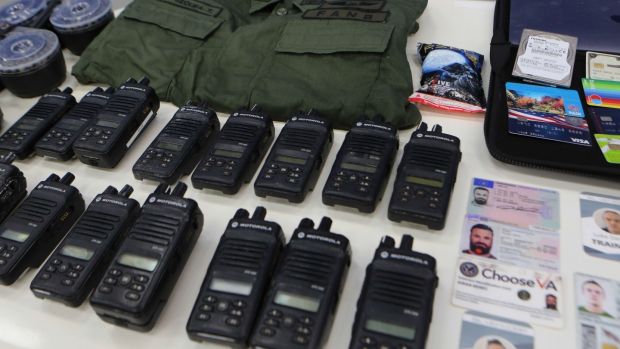 Identification cards, two-way radios and other military gear allegedly seized from US citizens arrested by Venezuelan security forces during a meeting with members of the Bolivarian National Armed Forces at Miraflores presidential palace in Caracas on Monday. Photograph: Marcelo Garcia/Venezuelan presidency/AFP via Getty Images