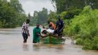 Residents from Busia County, Kenya, navigate flood waters after the Nzoia river  burst its banks. The deluge was compounded by backflow from Lake Victoria. Photograph: Reuters