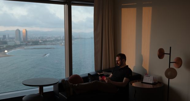 Daniel Ordoñez reads in his room on the 24th floor of the W Hotel in Barcelona. Ordoñez has lived there since March, the sole occupant in the luxury hotel.  Photograph: Samuel Aranda/The New York Times)