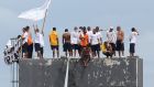 Inmates and a hostage on the top of a tower of the Puraquequara prison during a rebellion during which seven prison guards were taken hostage, in Manaus. Photograph: Michael Dantas/AFP via Getty