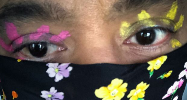 Accentuate the positive: make-up artist Nick Barose’s brightly painted eyes, to match a floral face covering