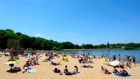 Sun bathers enjoy the warm weather at Ruislip Lido in  London on Saturday. Boris Johnson has set out a gradual easing of lockdown measures in England, with socially distanced groups of six friends and families allowed to meet in parks and gardens from Monday. Photograph: AFP 