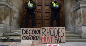 Police stand in front of Oriel College during a protest of the ‘Rhodes Must Fall’ campaign. Photograph: Will Oliver/ EPA