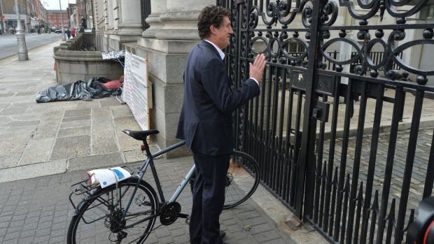 Green Party leader Eamon Ryan waits for the gates of Government Buildings to open after arriving by bike for talks on Government formation. Photograph: Alan Betson/The Irish Times