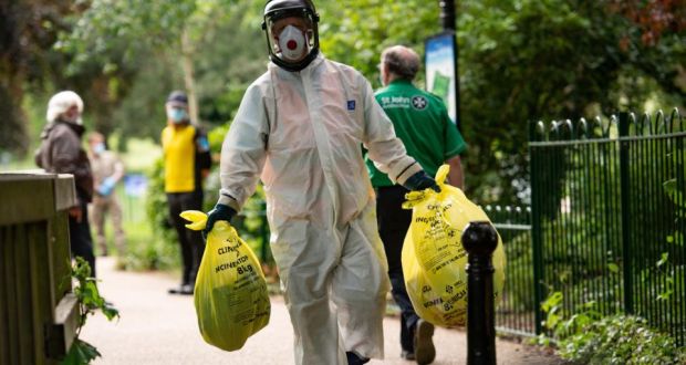 Spinney Hill Park in Leicester: A council worker carries rubbish from a coronavirus testing centre. Photograph: Jacob King