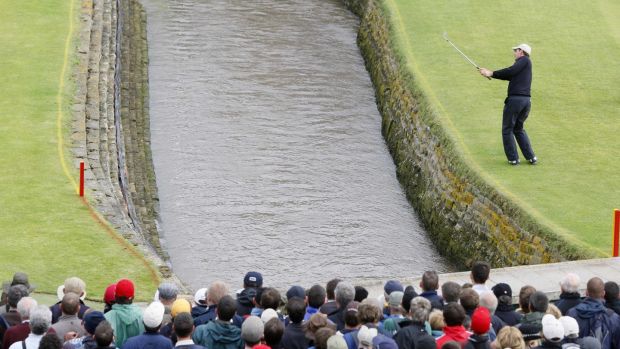 Pádraig Harrington hits over water of the Barry Burn onto the 18th green after hitting his second of two shots into the water on the 18th hole in regulation play. Photograph: Phil Noble/Reuters