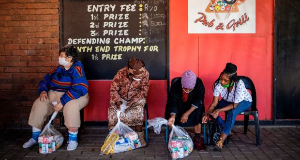 People check the food parcels they   received  in Brakpan, Gauteng province, where coronavirus cases have surged. Photograph:  Michele Spatari/AFP via Getty Images