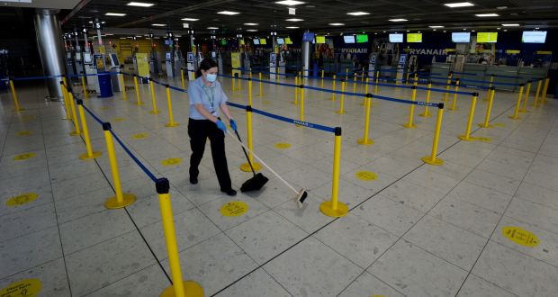 A member of the cleaning staff  at Dublin Airport. The use of face masks is a remarkably efficient way of reducing contagion. Photograph: Alan Betson.