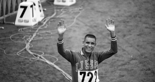 Billy Mills of the USA waving and smiling after winning the 10,000 metre race at the 1964 Olympics. Photo: Getty Images