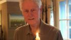 Bill Clinton with a candle lit in honour of John Hume. 